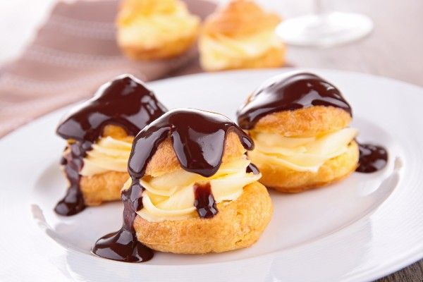 A plate filled with three profiteroles