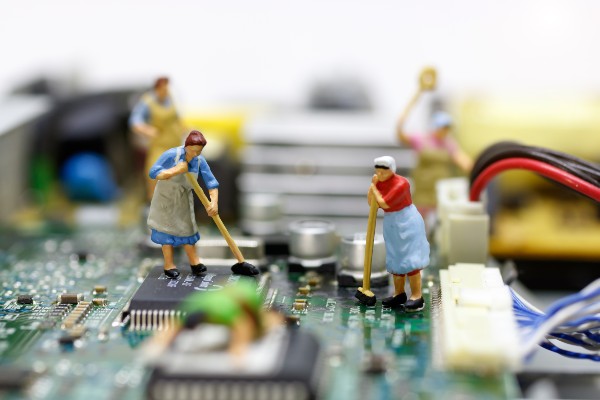Figurines of tiny people cleaning a motherboard